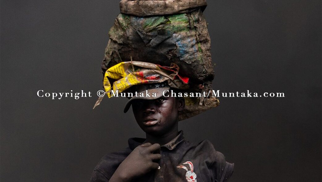 Making a final push following the demolition of the Agbogbloshie Scrapyard, an urban poor man emerges from a wall of thick smoke with tears trickling down his cheeks. The Agbogbloshie Scrapyard was a lifeline for thousands of Accra's urban poor. Copyright © Muntaka Chasant